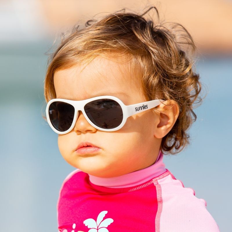 Small girl wearing white children's sunglasses