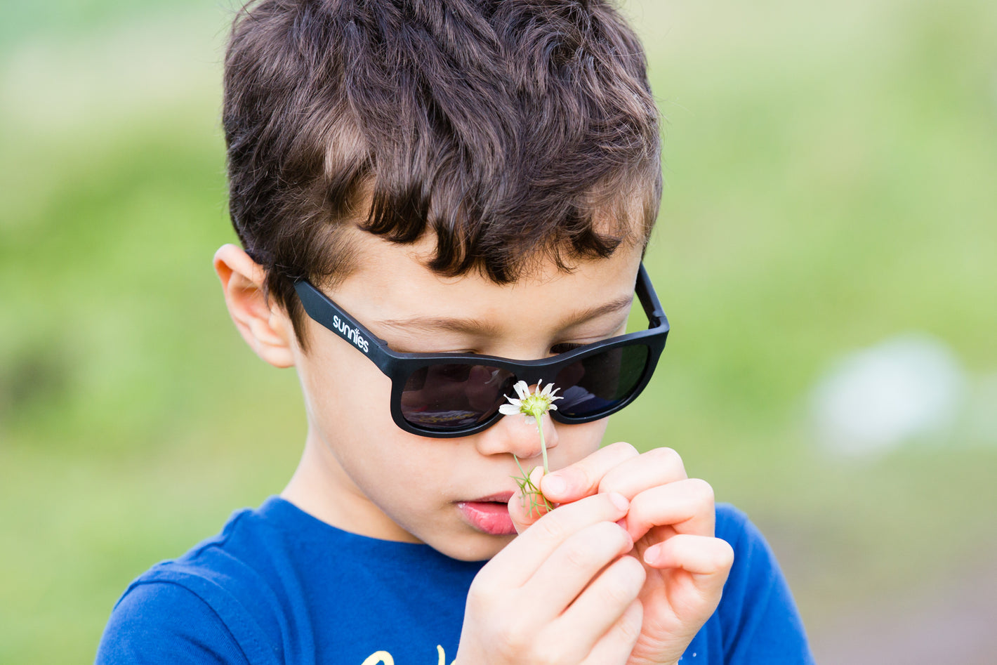 Child wearing sunglasses wearing black sunglasses