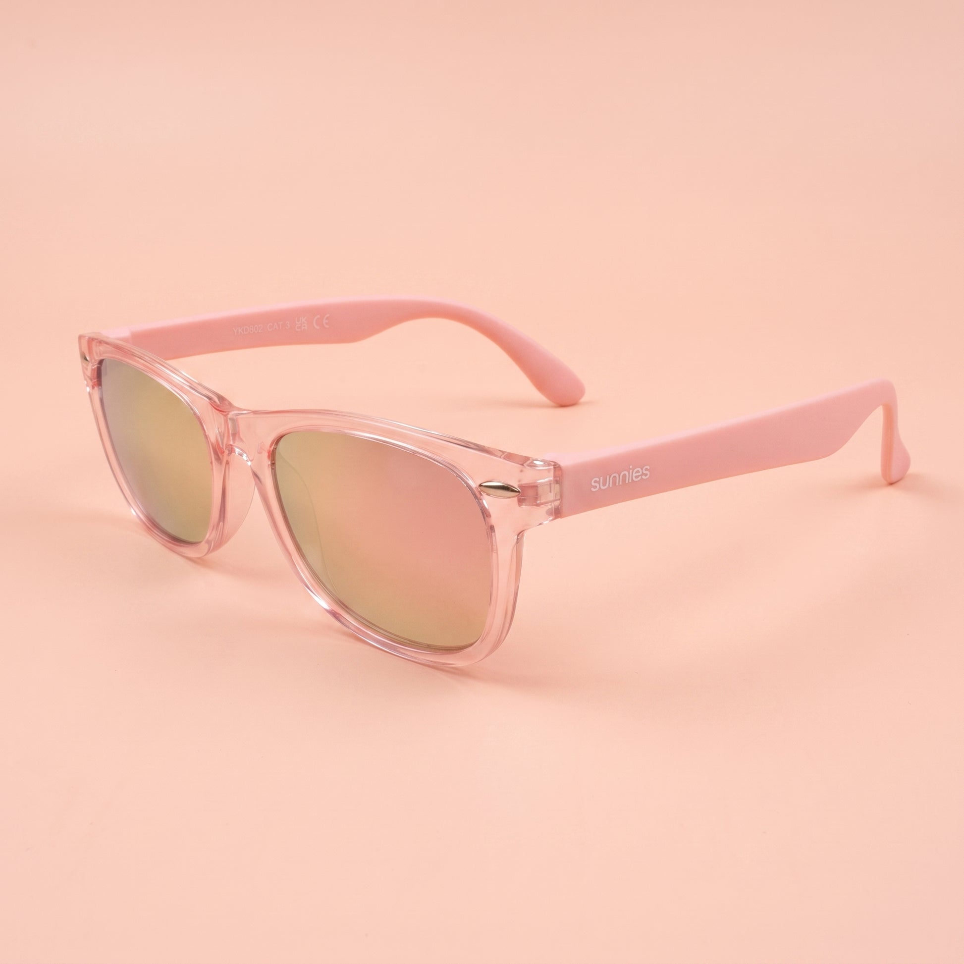 hero: A NEW photorealistic photograph composed from scratch. The product is placed on a seamless light peach-pink studio background that subtly dissolves into the floor, creating a cohesive, light environment. The scene is illuminated by broad, soft wraparound diffusion originating from slightly above and camera-front, complemented by gentle bounced fill light that meticulously rounds the product's form, ensuring even tonality across all surfaces. A single, soft grounding contact shadow is cast directly be…